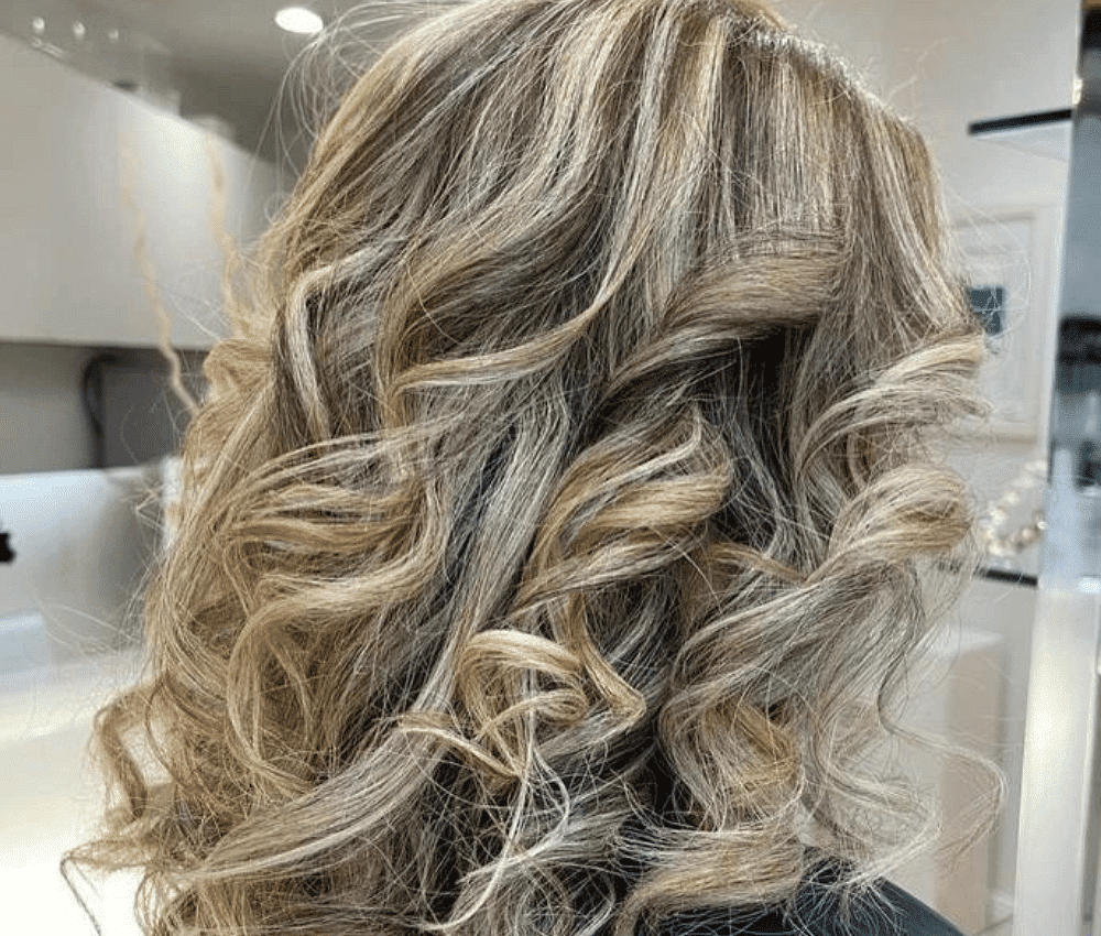 Blonde hair with soft waves showcased in a salon setting.