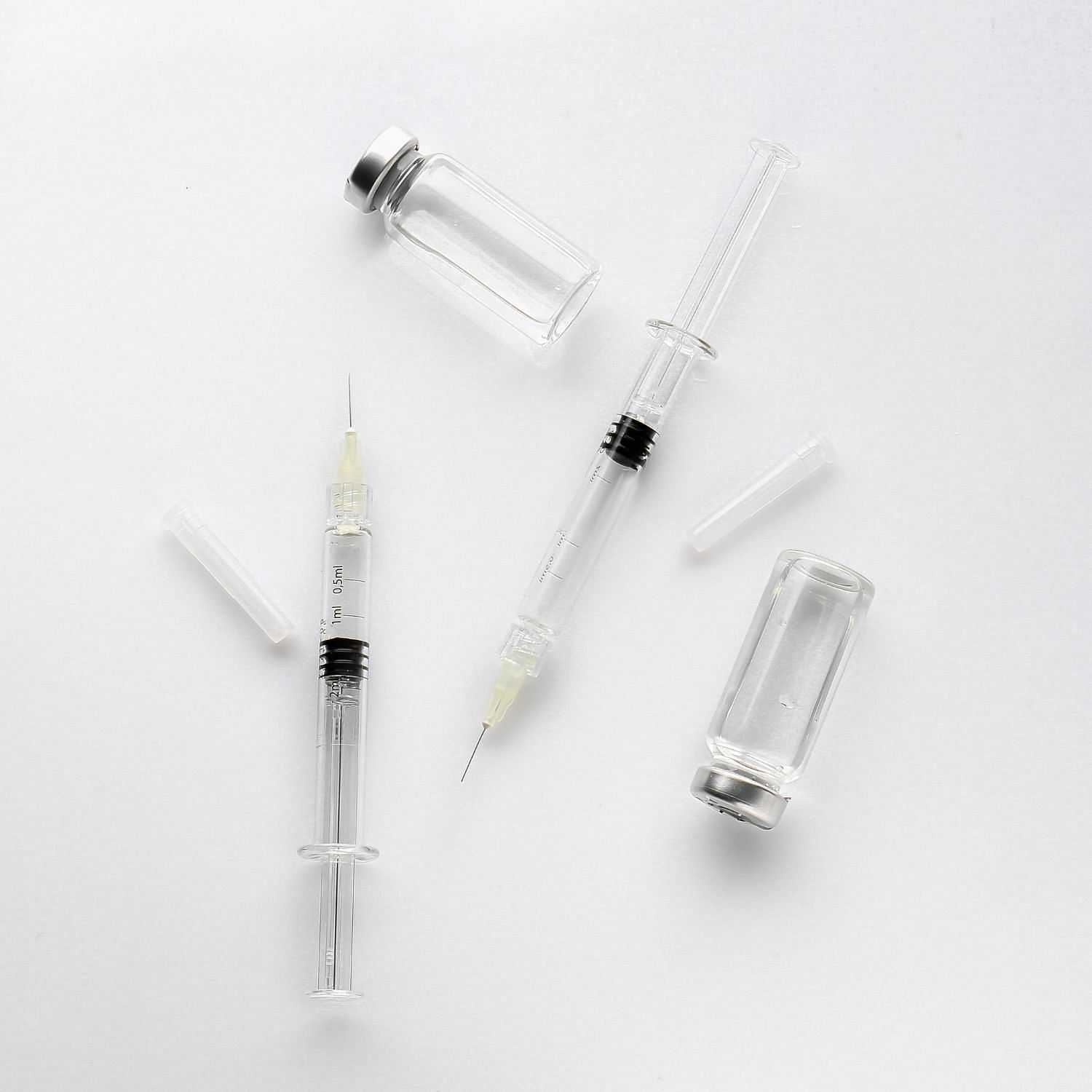 Medical syringes and vials on a white background.