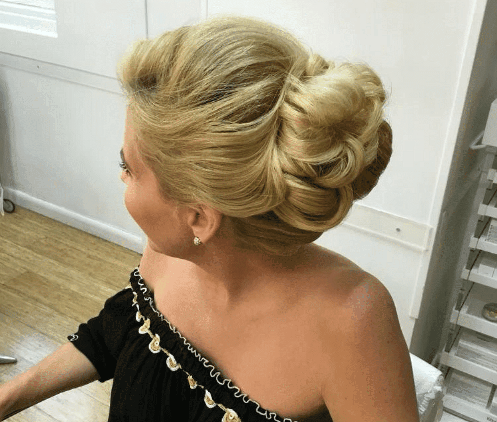 Woman with an elegant updo hairstyle in a salon setting.